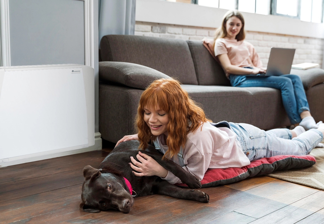 MyCond SEC/F En pige og hendes hund ved siden af en fan coil-enhed.